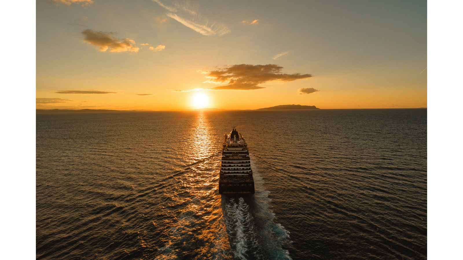 Um navio Explora Journeys a navegar ao pôr do sol