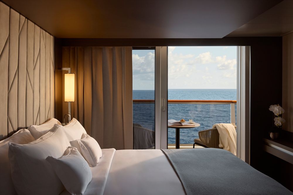 A Grand Penthouse bedroom aboard Explora Journeys with sea views through the terrace doors
