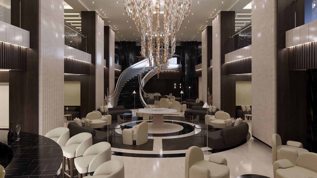 The lobby of an Explora Journeys ship, with a sweeping staircase and a glittering chandelier